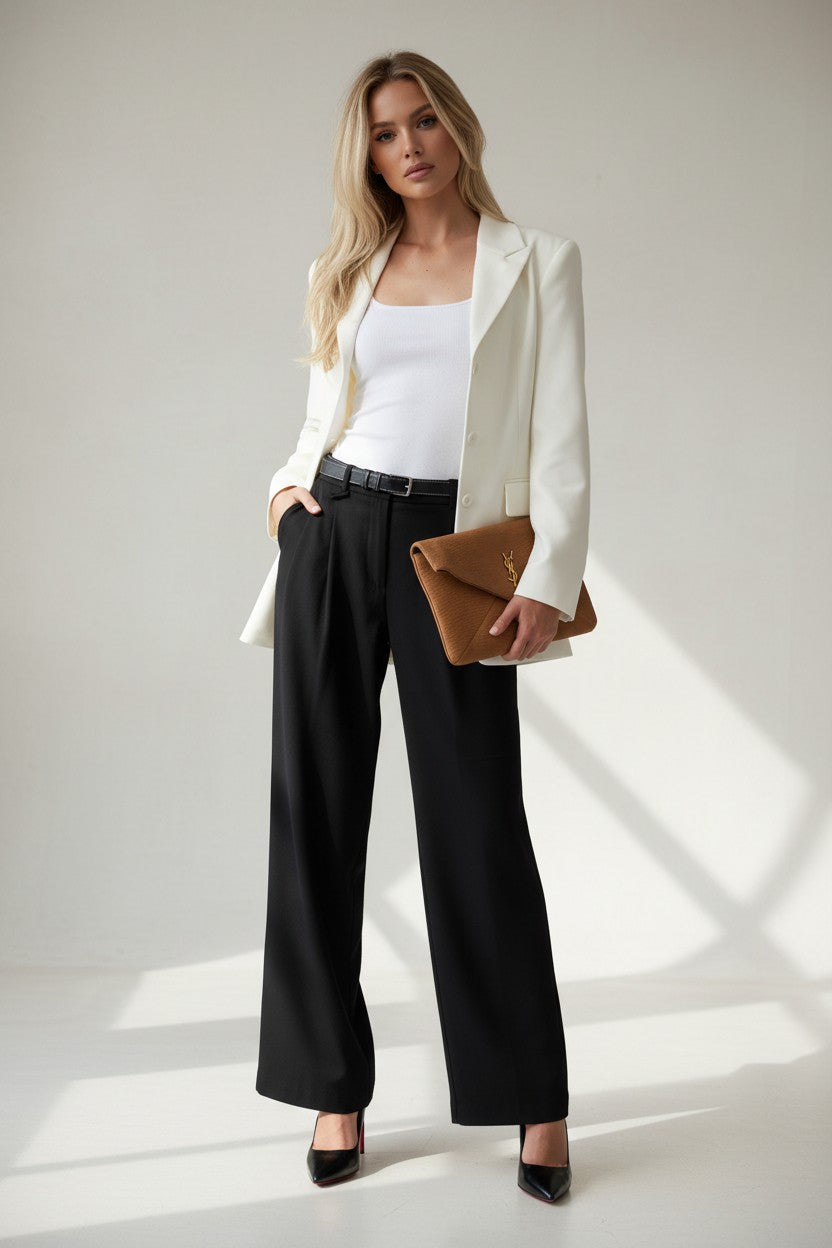 Model in a white blazer holding a brown Saint Laurent envelope clutch